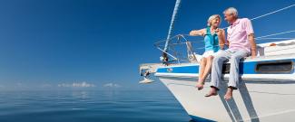 Older couple embracing on a boat overlooking a body of water